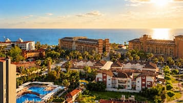 A resort with multiple buildings, a swimming pool, and a view of the ocean.