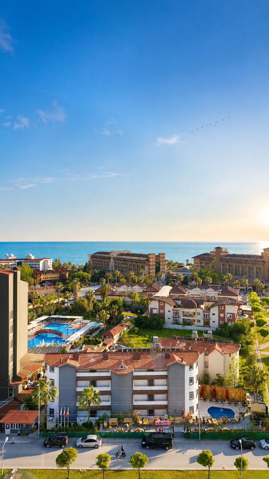 Ein Resort mit mehreren Gebäuden, einem Schwimmbad und Blick aufs Meer.