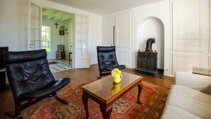 A spacious living room with a large wooden coffee table, two leather armchairs, and a patterned rug. - L'If, ground floor flat in a beautiful house, close to the beach (Varengeville-sur-Mer)