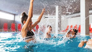 Une piscine où des personnes pratiquent diverses activités aquatiques.
