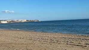 Une plage avec un ciel dégagé et une mer calme.