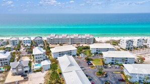 A resort with multiple buildings, a parking area, and a beach. - SurfsideVilla-3BR/2BA - Steps from the Sand! (Santa Rosa Beach)
