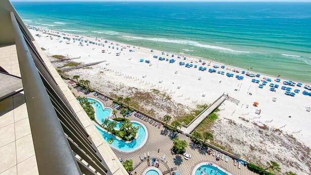 A beach resort with a pool area, beach umbrellas, and a view of the ocean. - Phoenix West, Lazy River, Beachfront, New Rental!! (Orange Beach)