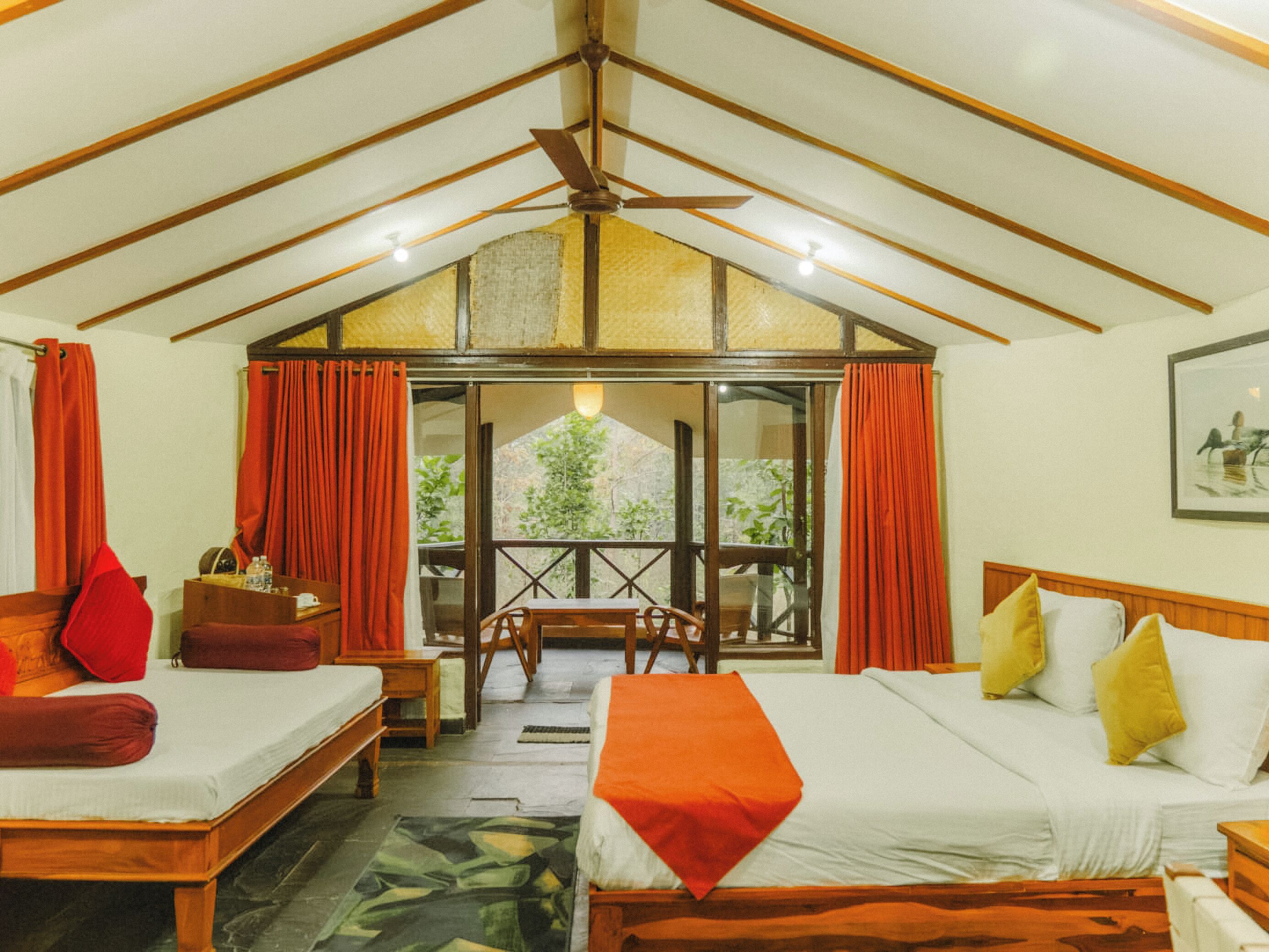 Quarto com cama, sofá, mesa e janela com cortinas.