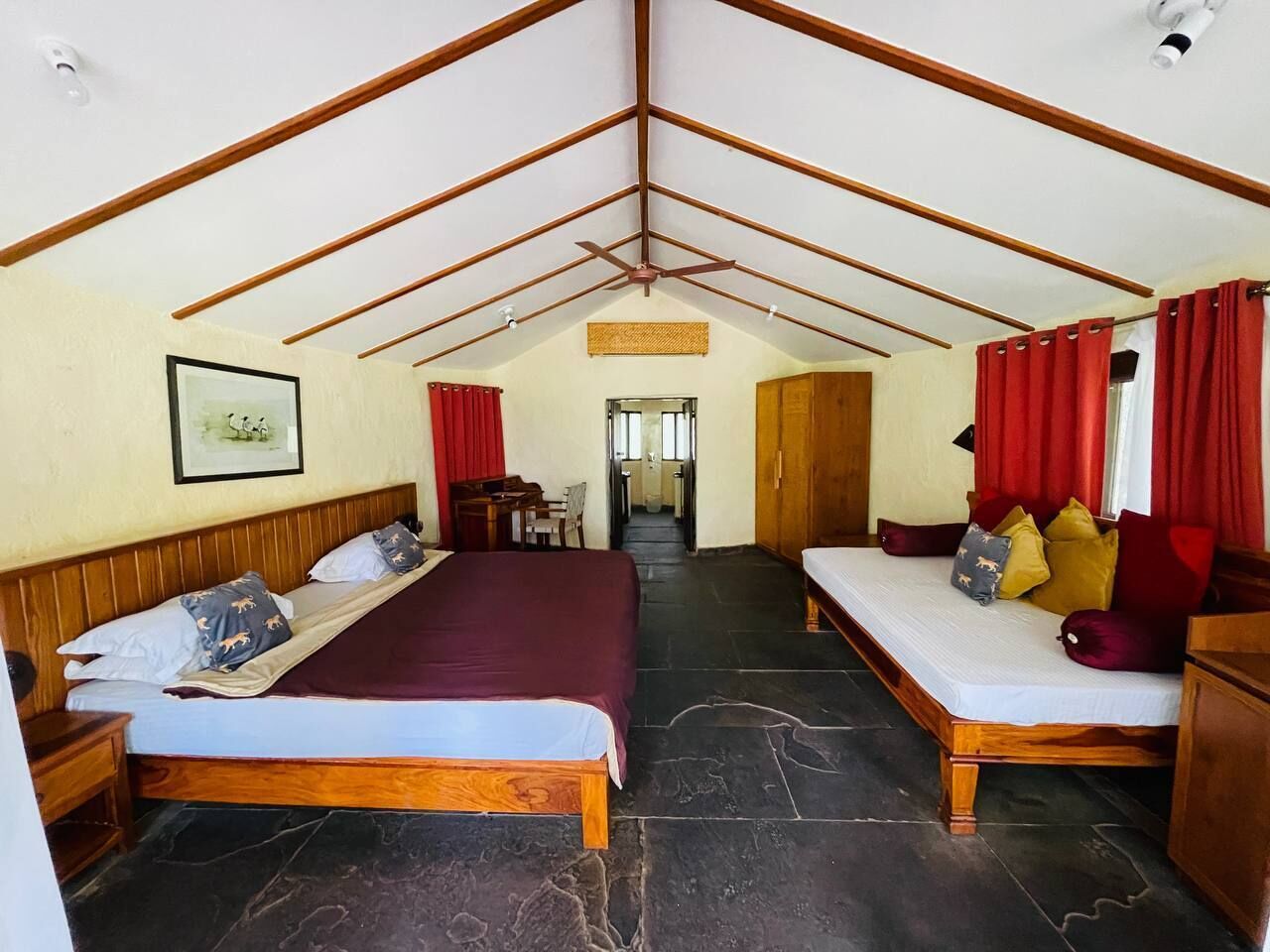 Ein Schlafzimmer mit zwei Betten, einer Holzbalkendecke und einem Steinboden.