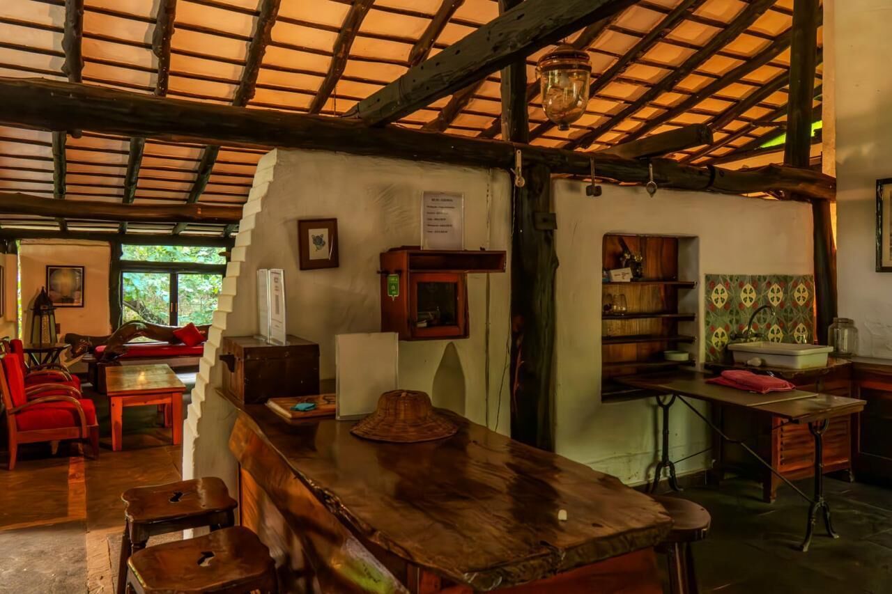 A rustic interior with wooden furniture, a bar area, and a kitchen with traditional decor.
