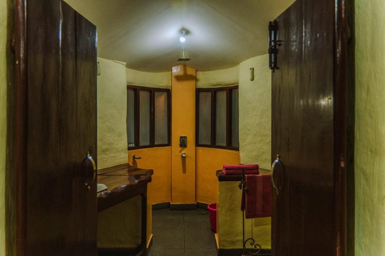 A narrow hallway with wooden doors, a small sink, and a red towel hanging on a rack.
