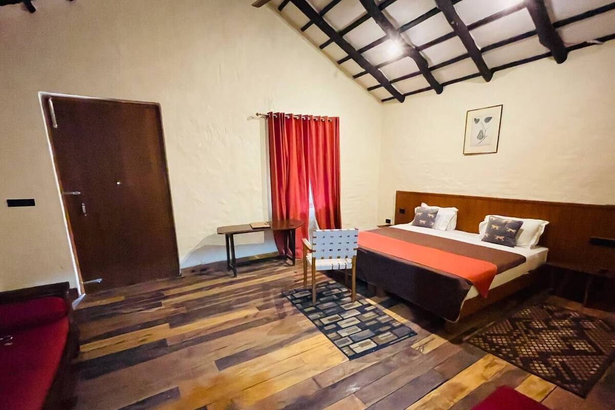 Une pièce avec un lit, une chaise, une petite table et une porte.