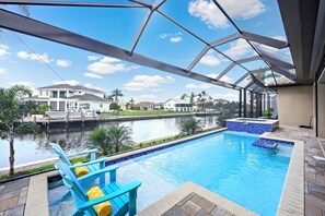 A swimming pool with a view of a canal and houses in the background.