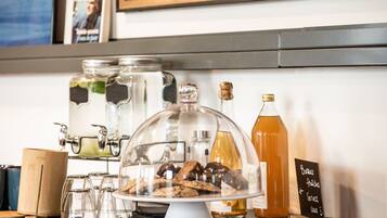 A bar area with a glass display case, a bottle of amber liquid, and a chalkboard menu.