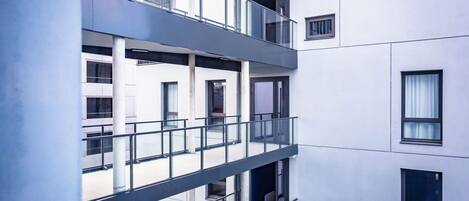 Un edificio de varios pisos con balcones, ventanas amplias y un estilo arquitectónico moderno.