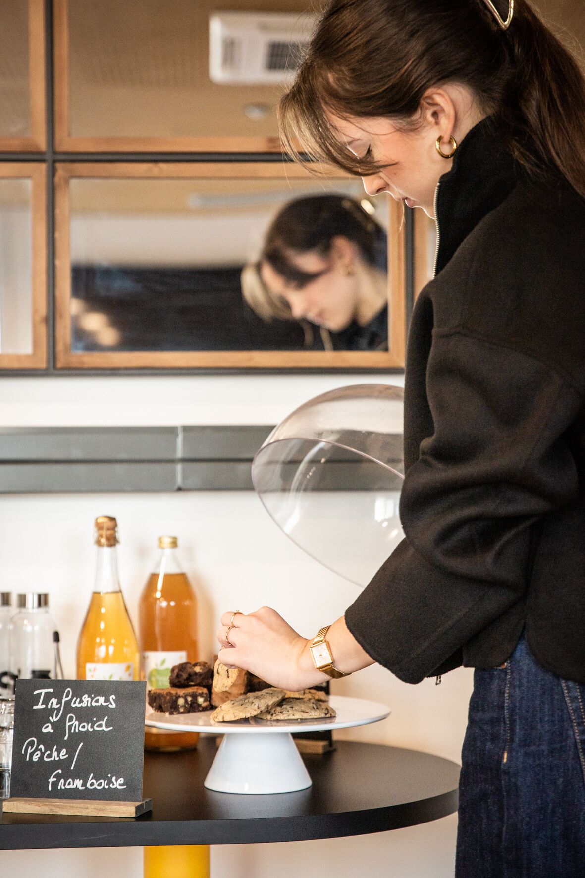 A person serving food at a counter with a sign indicating 'Impurions a froid Péche / Francoise'.