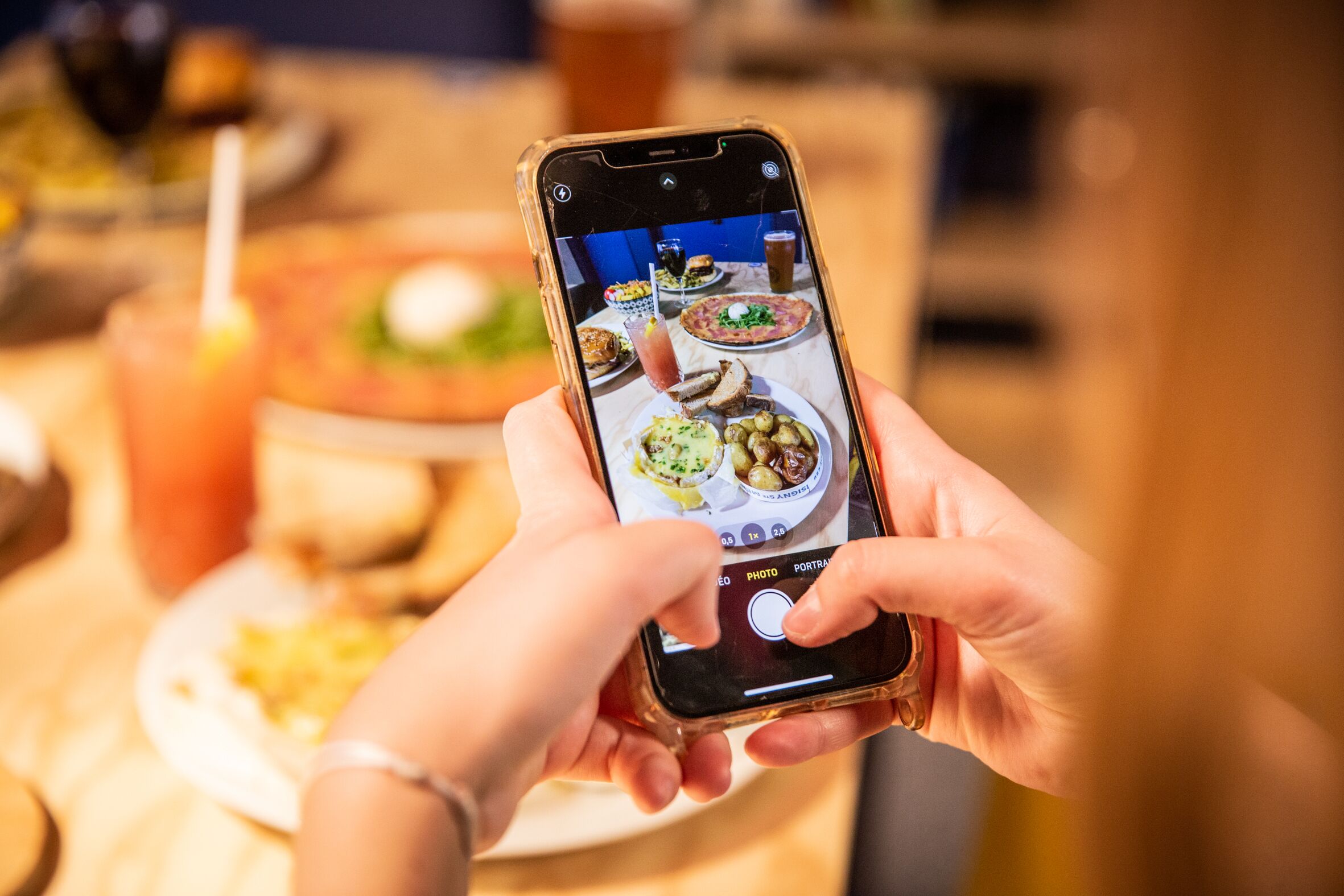 A person holding a smartphone with a photo of a meal on the screen.