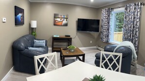 A modern living room with a sofa, a coffee table, and a TV.