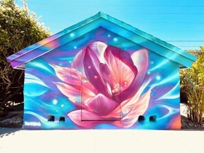 A house with a vibrant floral mural on its side. - Mega Group Block: 4 Units | Sleeps 10-16 (Deerfield Beach)