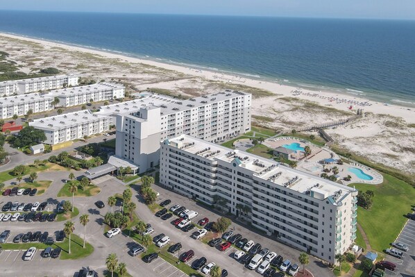 Un grand hôtel à plusieurs étages, doté d’un parking et offrant une vue sur la plage.