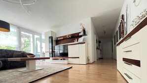 A modern kitchen with white cabinets, a wooden countertop, and a built-in oven.
