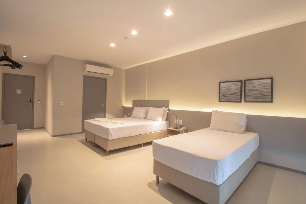 Una habitación de hotel moderna con dos camas, un escritorio y una silla.