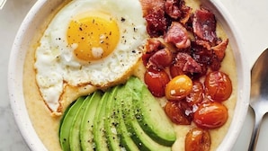 Un plato de comida con huevo, tocino, aguacate y tomates cherry.