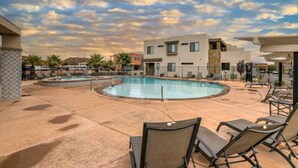 A pool area with lounge chairs and a modern building in the background. - What a rooftop deck! (Washington)