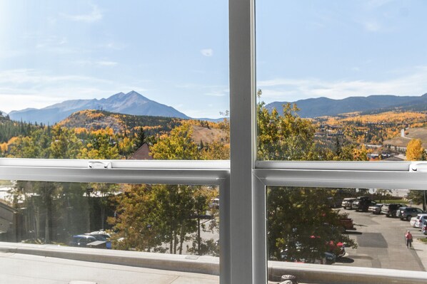 A view through a window with a mountain in the background and a parking lot in the foreground.