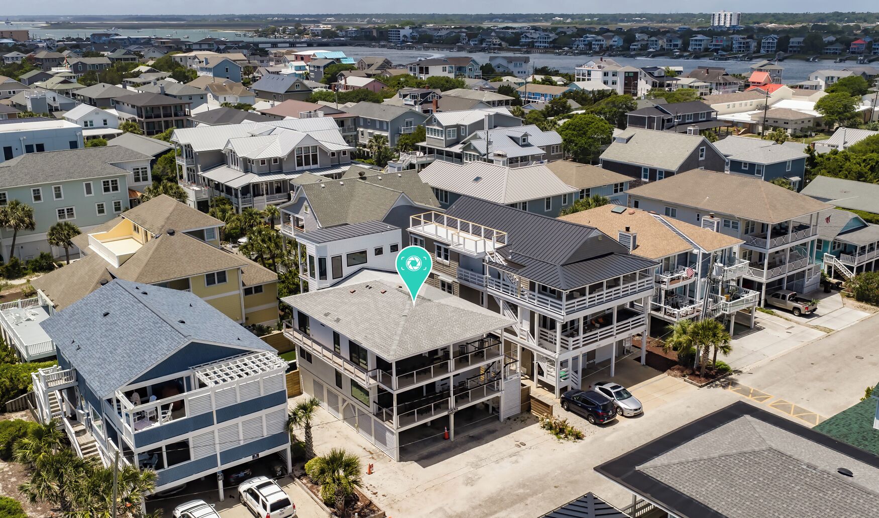 A residential area with multiple houses, a central building with a balcony, and a clear view of the surrounding neighborhood.