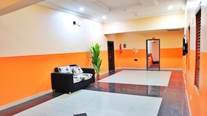 A hotel lobby with a black sofa, a potted plant, and a tiled floor. - Annes luxury suites  (Lagos)