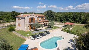A two-story house with a swimming pool, outdoor seating, and a stone wall. - Enchanting Villa Marijanin Vrt with swimming pool (Tinjan)