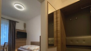A modern bedroom with a bed, a desk, and a built-in bench. - Hotel Restaurant Steinhägerquelle (Steinhagen)