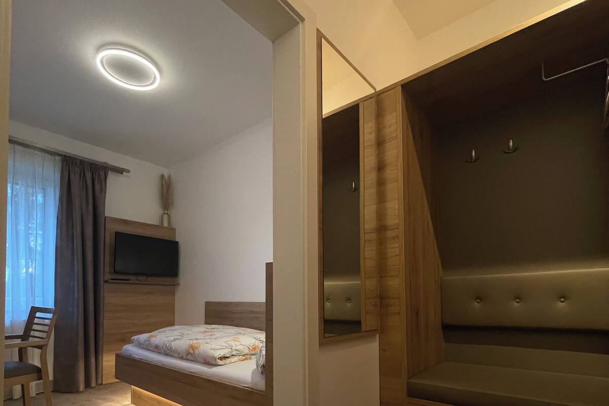 Ein modernes Schlafzimmer mit Bett, Schreibtisch und integriertem Sitzbank.