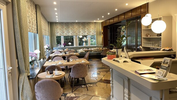 A modern restaurant with a bar area, seating arrangements, and a counter with a menu display. - Hotel Restaurant Steinhägerquelle (Steinhagen)