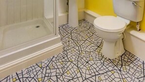 Une salle de bain avec une douche à parois de verre, un lavabo blanc et des toilettes.
