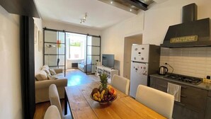 A modern kitchen with a wooden dining table, a refrigerator, and a stove.