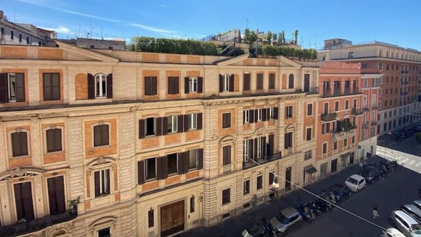 A multi-story building with a classical architectural style, featuring arched windows and a central entrance.