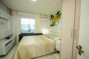 Quarto com cama, janela com cortinas, pintura de flores e guarda-roupa.