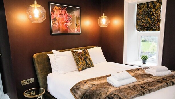 Ein Schlafzimmer mit einem großen Bett, einem Fenster mit Ausblick und einem Bild an der Wand.