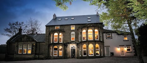 A large, historic building with multiple windows and a central entrance.