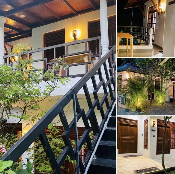 A multi-level building with a staircase, outdoor seating area, and a well-lit entrance.