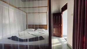 Une chambre à coucher avec un lit, une tête de lit en bois et une porte.