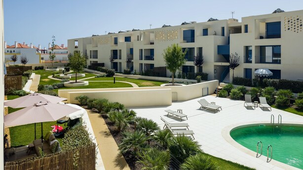 Un hôtel moderne doté d’une piscine, d’un espace extérieur aménagé et d’un jardin bien entretenu.