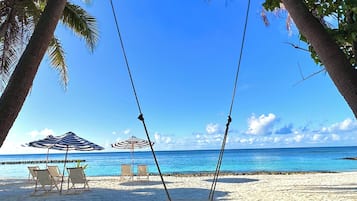 Playa privada, arena blanca, sombrillas, toallas de playa