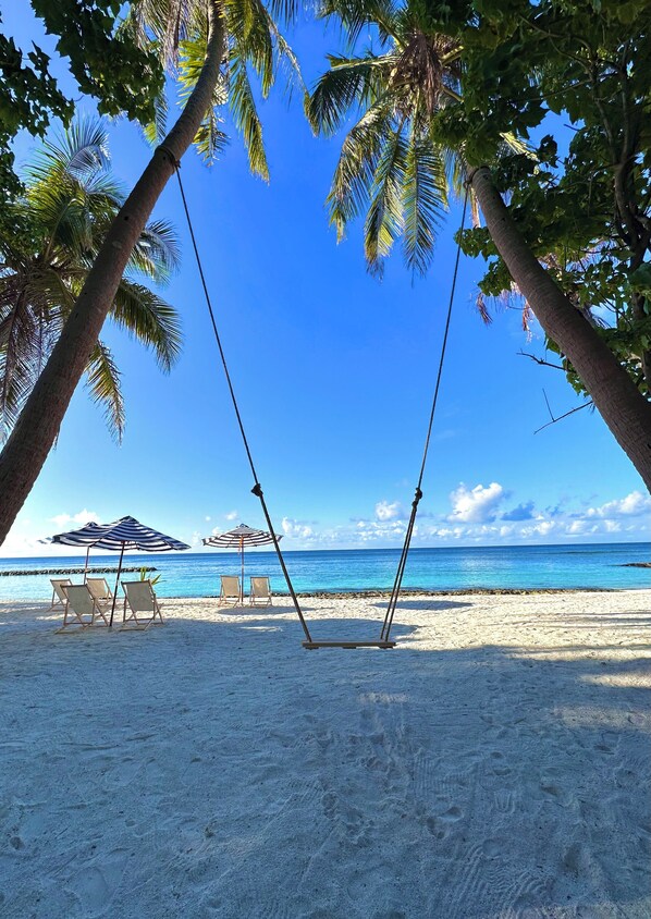 Platja privada, platja de sorra blanca i para-sols per a la platja 