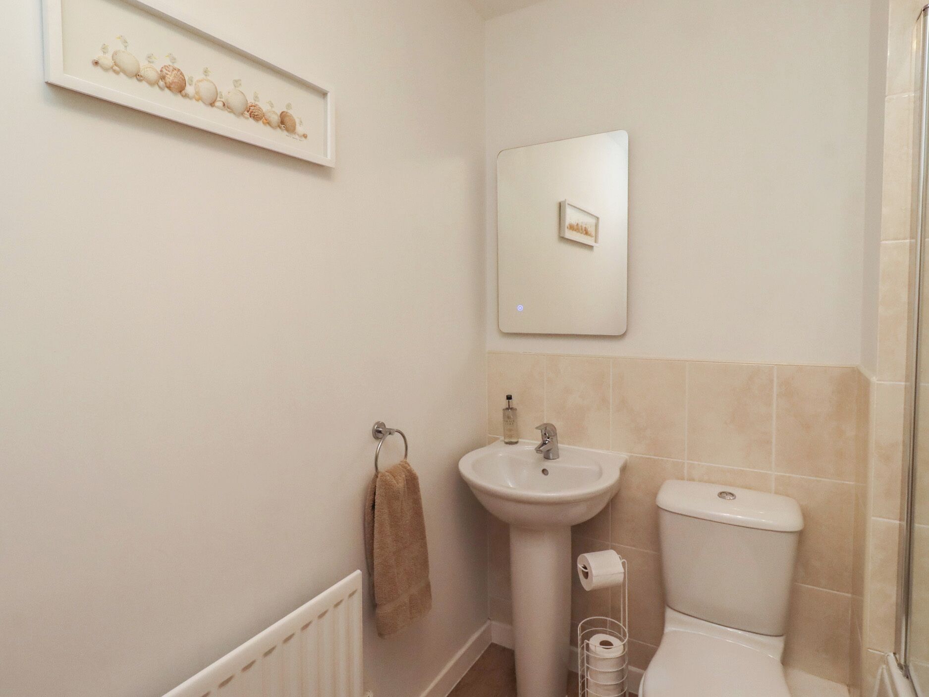 A bathroom with a sink, toilet, and a towel rack.