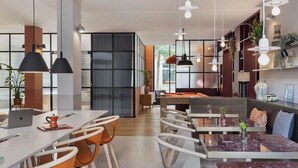 Een moderne keuken met een eethoek, met een marmeren tafel, stoelen en hanglampen.