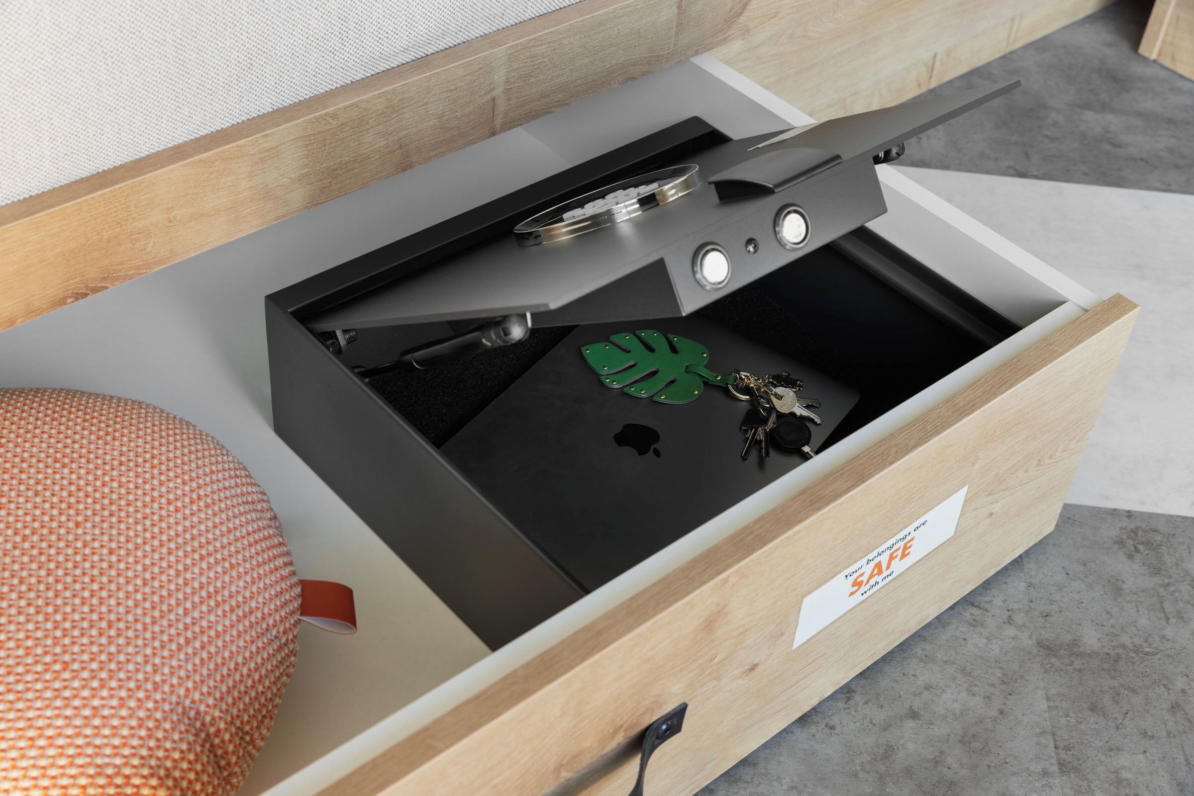 A drawer with a black interior, a metal container, and a keychain.