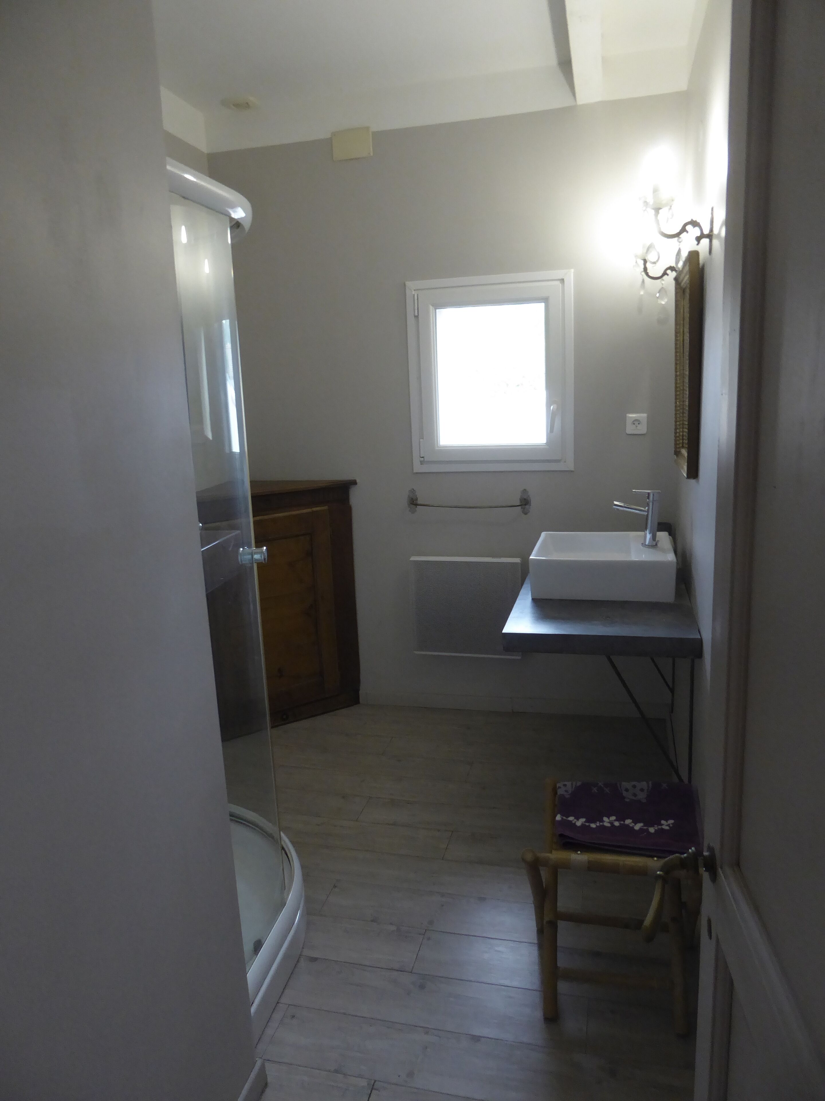 A small bathroom with a toilet, sink, and window.