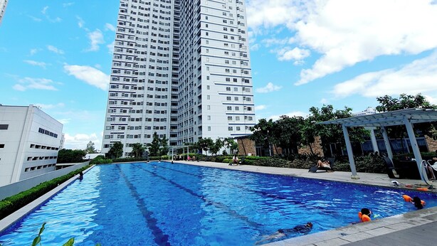 Un edifici modern i alt amb una piscina al primer pla.