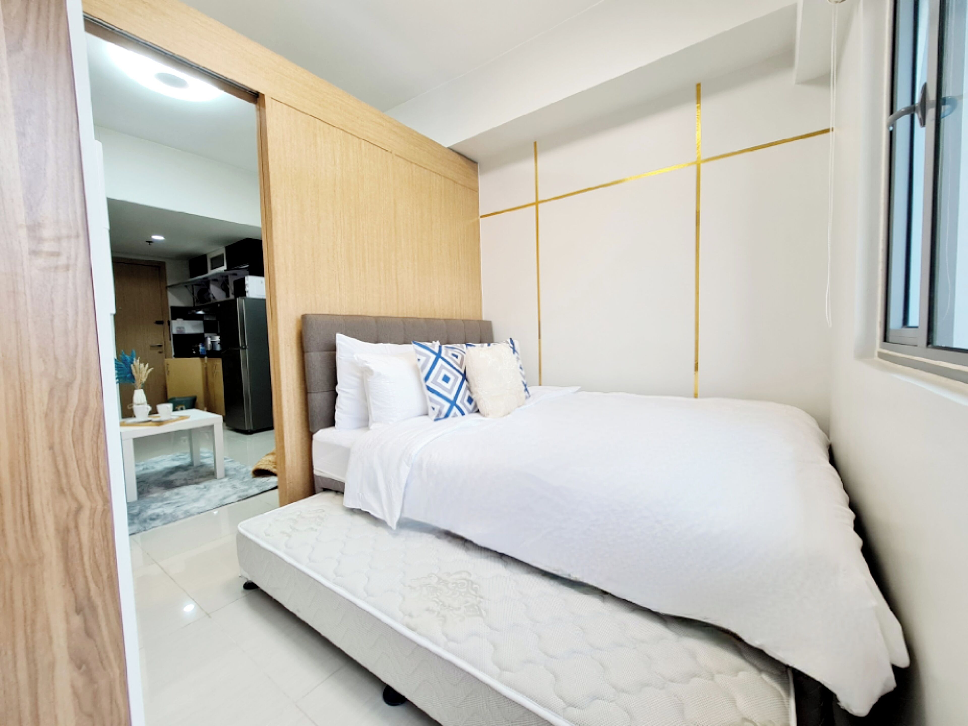 A modern bedroom with a bed, a small table, and a wardrobe.