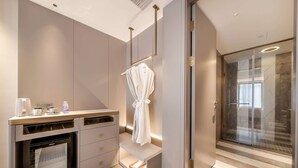A modern bathroom with a built-in oven, a vanity with drawers, a robe hanging on a towel rack, and a glass shower enclosure. - Howard Johnson Life Hotel by Wyndham Chongqing Liangjiang (Chongqing)