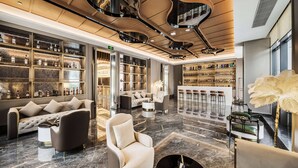 A modern lobby with a marble floor, sofas, armchairs, and a bar area with shelves of bottles. - Howard Johnson Life Hotel by Wyndham Chongqing Liangjiang (Chongqing)
